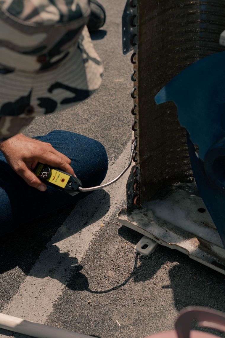 AC Repair showing a technician performing air conditioner maintenance